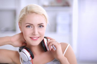 Evdeki genç ve güzel kadın kanepede oturup müzik dinliyor.
