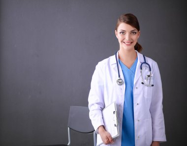 Steteskobu olan doktor kadın gri arka planda izole edilmiş.