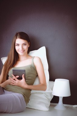 bir yastık ve uçak tablo ile katta oturan güzel esmer kadın