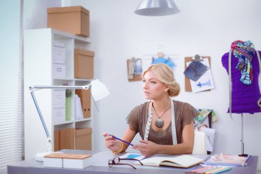 Stüdyoda çalışan genç moda tasarımcısı.