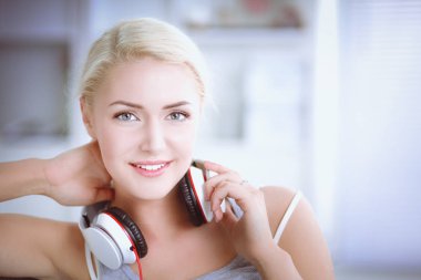 Evdeki genç ve güzel kadın kanepede oturup müzik dinliyor.