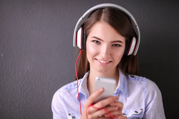 Gelukkig meisje zittend op de vloer en muziek luisteren — Stockfoto