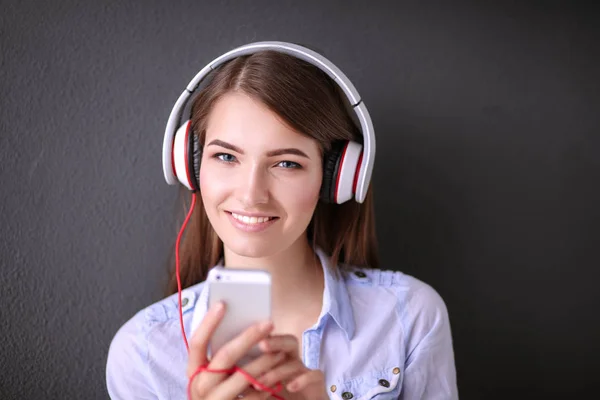 Gelukkig meisje zittend op de vloer en muziek luisteren — Stockfoto