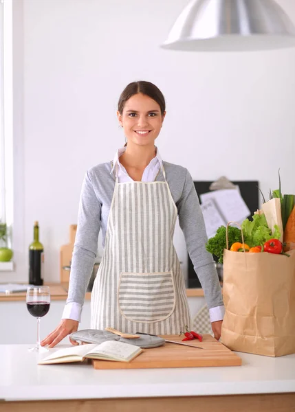 Mulher fazendo comida saudável em pé sorrindo na cozinha — Fotografia de Stock