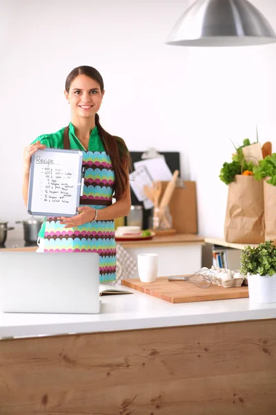 Vrouw in de keuken thuis, in de buurt van bureau met map — Stockfoto