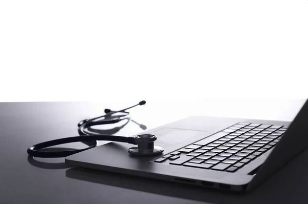 Laptop com pilha de pastas na mesa sobre fundo branco — Fotografia de Stock