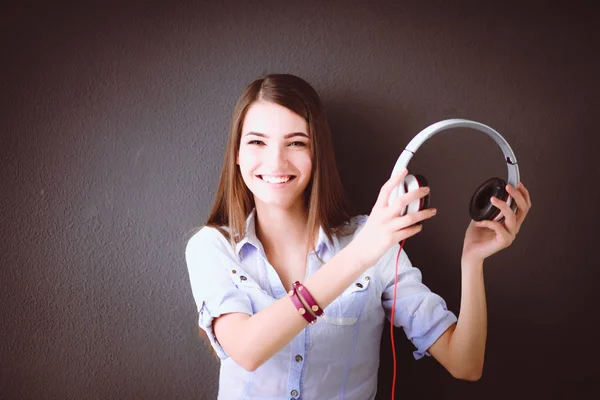 Gelukkig meisje zittend op de vloer en muziek luisteren — Stockfoto