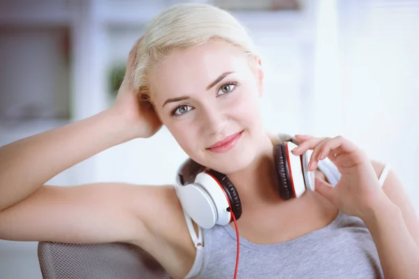 Joven hermosa mujer en casa sentada en el sofá y escuchando música —  Fotos de Stock