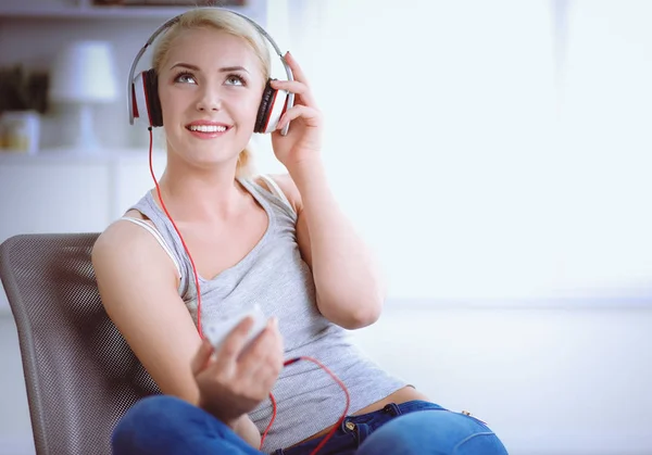 Giovane bella donna a casa seduta sul divano e ascoltare musica — Foto Stock
