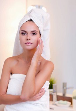 Banyo aynası önünde duran genç çekici kadın