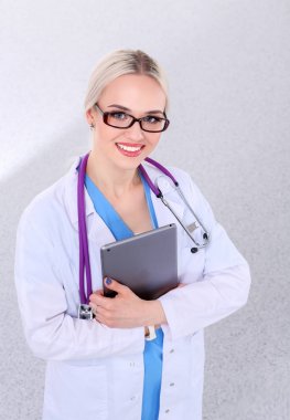 Dijital tablet kullanan ve beyaz arka planda duran bir kadın doktor. Kadın doktorlar.