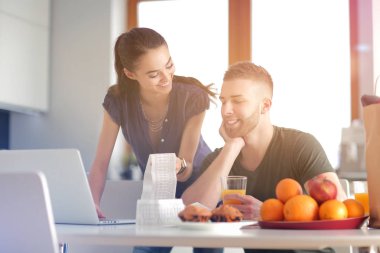 Çift evde mutfak içinde laptop ile onların fatura ödeme