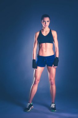 Spor giyim siyah arka plan karşı poz kas genç kadın.