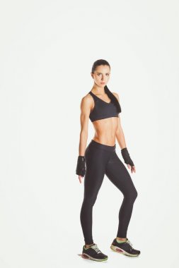 Beyaz arka plan karşı spor giyim poz kas genç kadın.