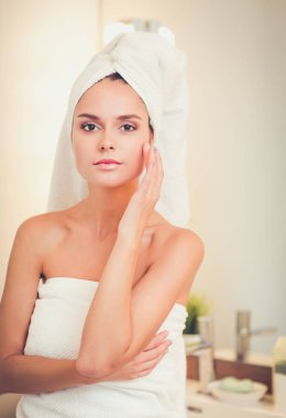 Banyo aynası önünde duran genç çekici kadın