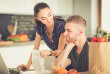 Çift evde mutfak içinde laptop ile onların fatura ödeme