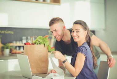 Çift evde mutfak içinde laptop ile onların fatura ödeme