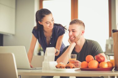 Çift evde mutfak içinde laptop ile onların fatura ödeme