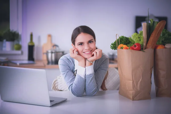 Leende kvinna online shopping med dator och kreditkort i köket — Stockfoto