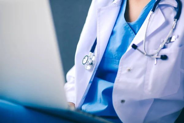 Mujer doctora con estetoscopio aislado sobre fondo gris — Foto de Stock