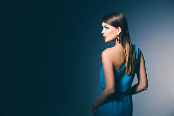 Νεαρή όμορφη γυναίκα με μακριά μαλλιά που θέτουν σε μπλε βραδινό φόρεμα — Φωτογραφία Αρχείου