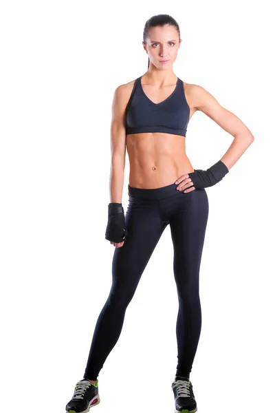Musclé jeune femme posant en vêtements de sport sur fond noir . — Photo