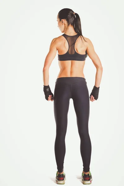 Mięśni młoda kobieta pozowanie w sportowej na białym tle. — Zdjęcie stockowe