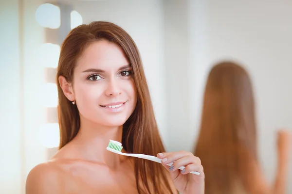 Retrato de una joven limpiándose los dientes — Foto de Stock