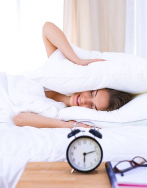 Genç bir kadın sabah alarmını erteliyor.