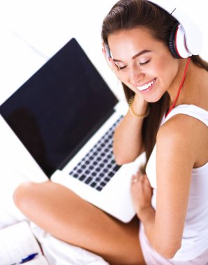 Genç güzel kadın yatakta müzik