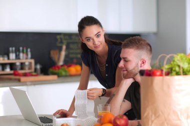 Çift evde mutfak içinde laptop ile onların fatura ödeme