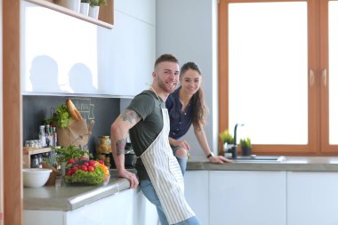 Güzel genç çift evde mutfakta eğleniyor.