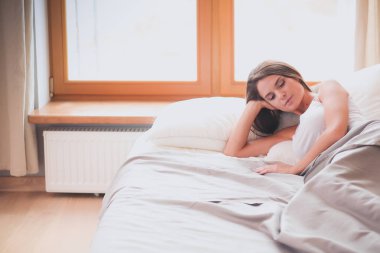 Evdeki yatakta uzanmış güzel esmer