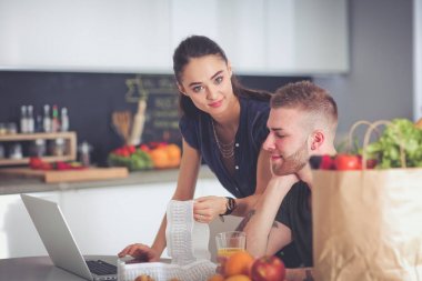 Çift evde mutfak içinde laptop ile onların fatura ödeme