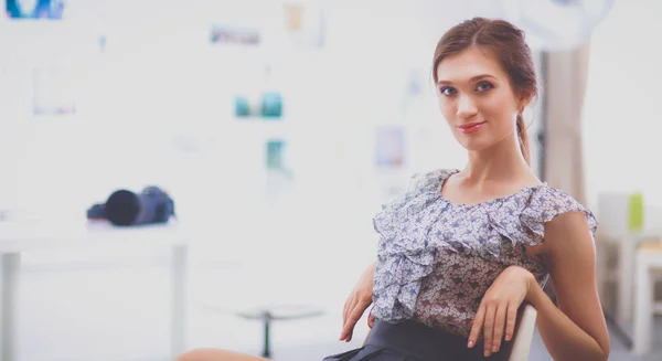 Attraktive Geschäftsfrau sitzt auf Schreibtisch im Büro — Stockfoto