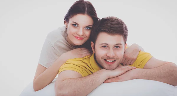 年轻貌美的夫妻躺在地板上，被白色的背景隔开 — 图库照片