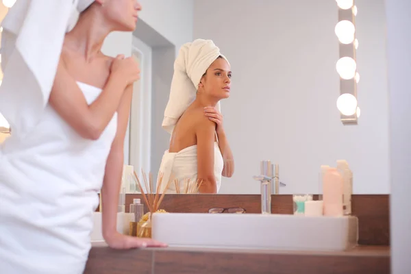 Jeune femme attrayante debout devant le miroir de salle de bain — Photo