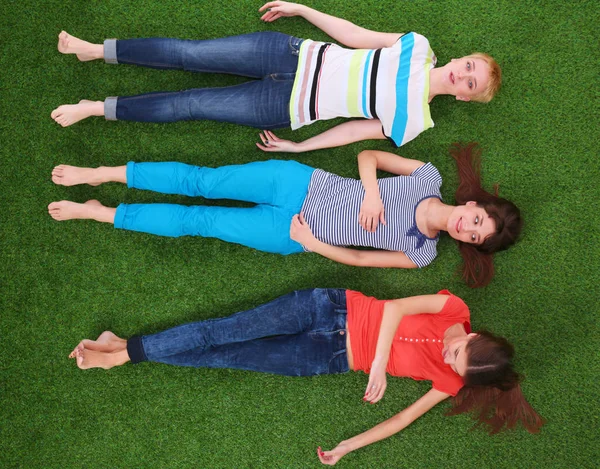Mujeres jóvenes tumbadas sobre hierba verde. Mujeres jóvenes — Foto de Stock