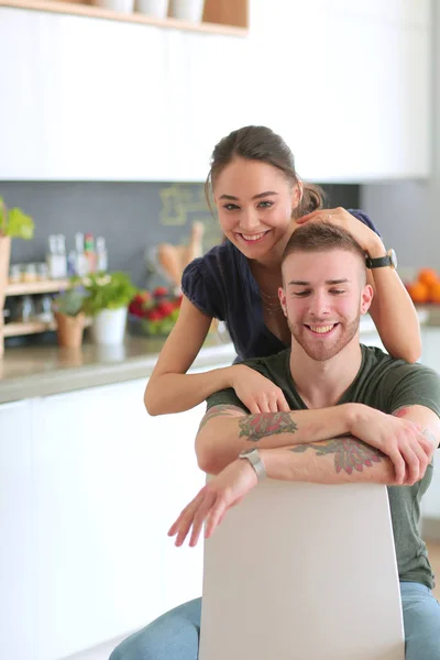 Belo jovem casal está se divertindo na cozinha em casa — Fotografia de Stock