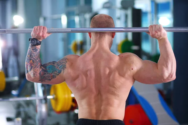 Culturista con barra de pesas en gimnasio. Culturista — Foto de Stock