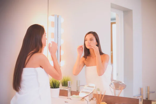 Attractive young woman applying cream on her Face — Stock Photo, Image