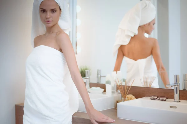 Jeune femme attrayante debout devant le miroir de salle de bain — Photo