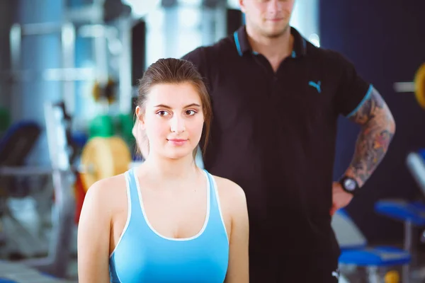 O femeie frumoasă la sala de gimnastică exersând cu antrenorul ei. Frumoasă femeie. Sala de sport — Fotografie, imagine de stoc