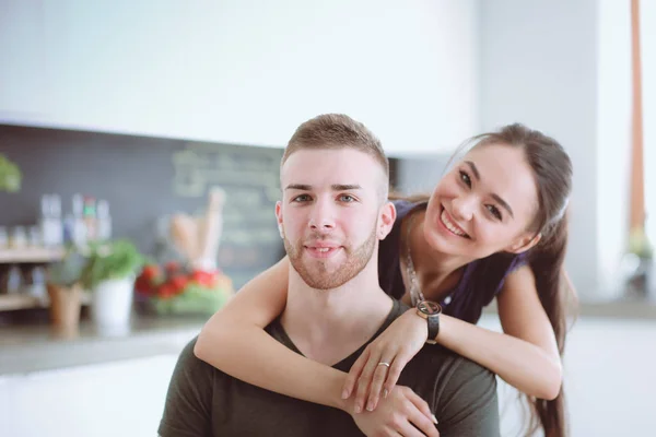 Belo jovem casal está se divertindo na cozinha em casa — Fotografia de Stock