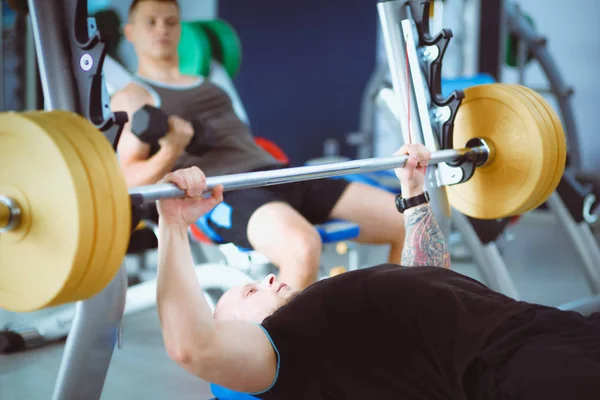 Culturista con barra de pesas en gimnasio. Culturista — Foto de Stock