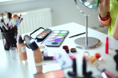 Genç güzel kadın ayna, Masa başında oturan yakınındaki makyaj yapma