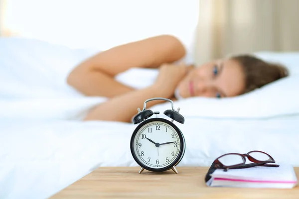 Une jeune femme éteint son réveil le matin — Photo