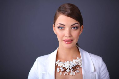 Boncuklar, gri arka plan üzerinde duran genç kadın portresi