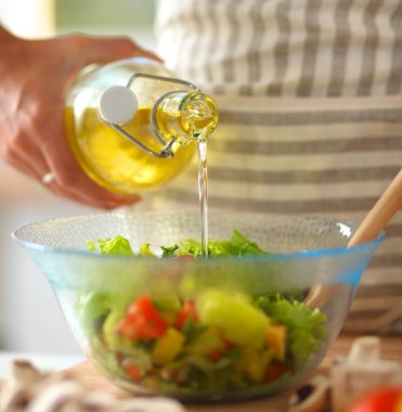 Genç kadın taze salata hazırlıyor.