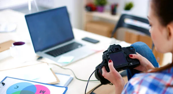 Femme photographe assise sur le bureau avec ordinateur portable — Photo